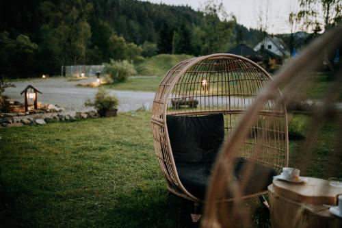 a bird cage sitting in the grass in a yard at Solny - Resort w Bieszczadach in Cisna