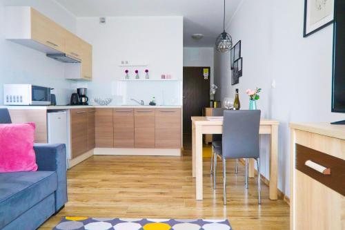 a kitchen and living room with a blue couch and a table at visit baltic - Villa Julia Studio Mola in Świnoujście