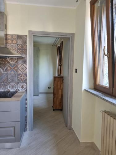 a kitchen with a door leading into a hallway at La Casa di Dedè monolocale in Sale