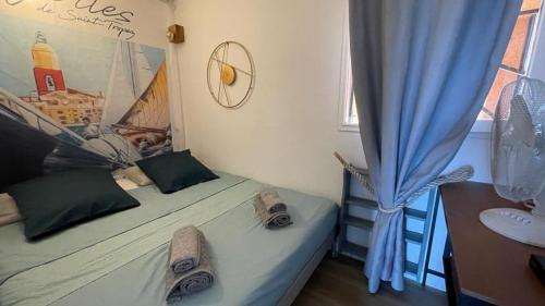 een slaapkamer met een bed, een wastafel en een raam bij Sylvabelle Gigaro Boat Spirit in La Croix-Valmer