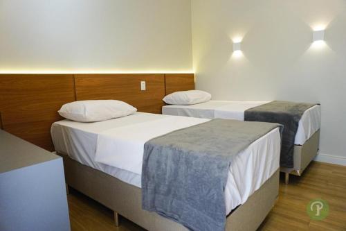 una habitación de hotel con 2 camas en una habitación en Hotel Park, en Valparaíso de Goiás