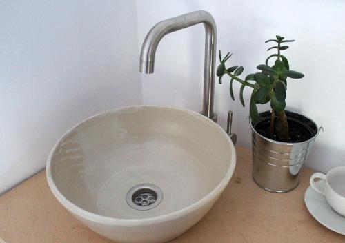 un lavabo à bol blanc avec une plante en pot sur un comptoir dans l'établissement jelenrét, 