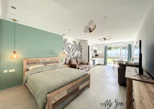 una camera con letto e un soggiorno di Studio de charme - Aly'Zen - Magnifique vue mer, les pieds dans l'eau a Le Moule