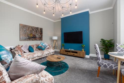 a living room with a couch and a tv at Ashton Mews apartment with free parking in Saint Annes on the Sea