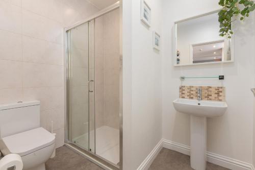 uma casa de banho com um chuveiro, um WC e um lavatório. em Ashton Mews apartment with free parking em Saint Annes on the Sea