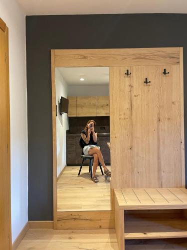 a woman sitting in a chair in front of a mirror at Hotel Rech-Hof Sayonara in Folgaria