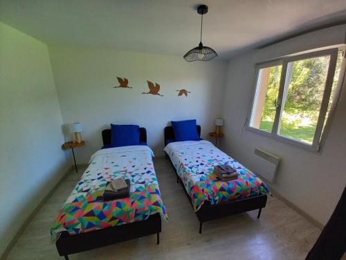 a bedroom with two beds and birds on the wall at Appt spacieux et lumineux pour 6 pers in Giffaumont