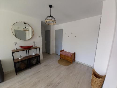 a living room with a mirror and a table at Appt spacieux et lumineux pour 6 pers in Giffaumont