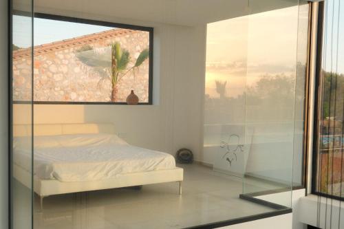 - une chambre avec un lit et un mur en verre dans l'établissement Contemporary villa near Sitges Hills, à Barcelone
