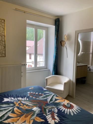 a bedroom with a bed and a chair and a window at Joly Saint Sauveur in Villard-Saint-Sauveur