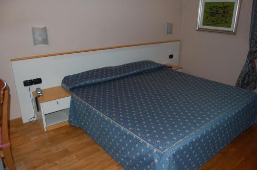 1 dormitorio con 1 cama con edredón azul en Albergo Ristorante Sant'Eustorgio en Arcore