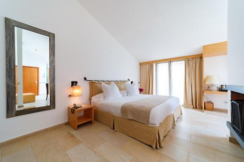a bedroom with a large bed and a mirror at Alberi del Paradiso in Cefalù