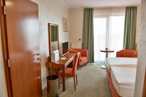 pokój hotelowy z sypialnią z biurkiem i łóżkiem w obiekcie Hotel Kralj w mieście Donji Kraljevec