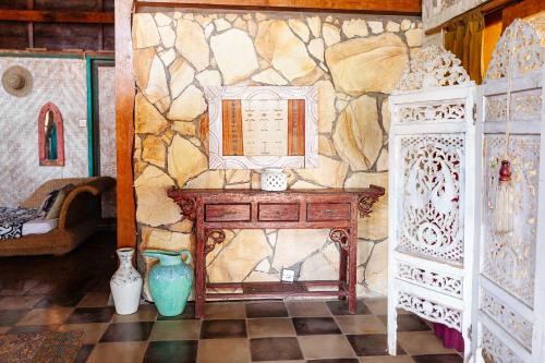 a room with a table and a stone wall at Unique Balian beach house in Antasari