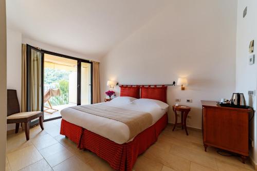 a bedroom with a large bed and a balcony at Alberi del Paradiso in Cefalù