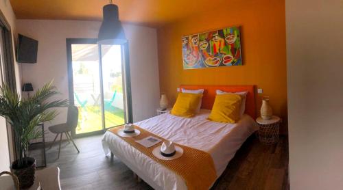 ein Schlafzimmer mit einem Bett mit einer orangefarbenen Wand in der Unterkunft Villa Marina in Sanary-sur-Mer