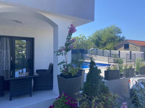 a balcony with potted plants and a swimming pool at HelaMoni, New 5 Star 2 Person apartments with pool in Malinska