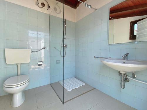 a bathroom with a shower and a toilet and a sink at Villa Pace by BarbarHouse in Torre Lapillo