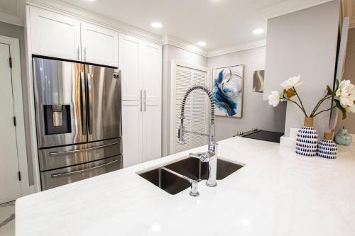 a kitchen with a sink and a refrigerator at Newly Listed! 20 Percent Off! Golf and Tennis Community - Lavish Living in Wesley Chapel