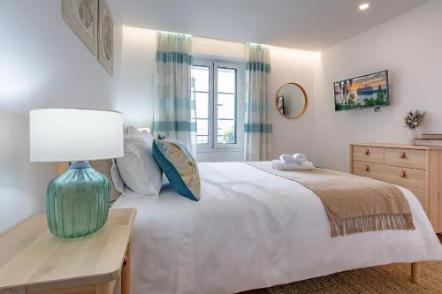 ein Schlafzimmer mit einem Bett und einem Tisch mit einer Lampe in der Unterkunft Casa de Sao Tiago 2 in Funchal
