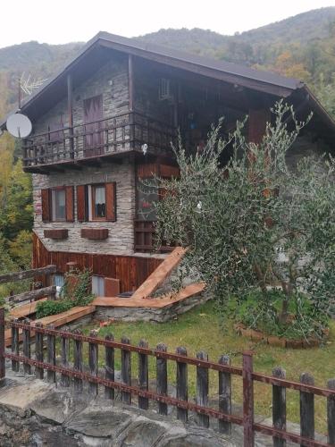 uma casa de madeira com uma varanda numa colina em Chalet di Montagna em San Giuliano