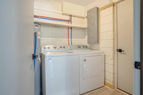 a small kitchen with a white stove and a washer at Luxury Beach House - 2min Walk to Beach - Private Pool - Group & Dog Friendly in Hilton Head Island