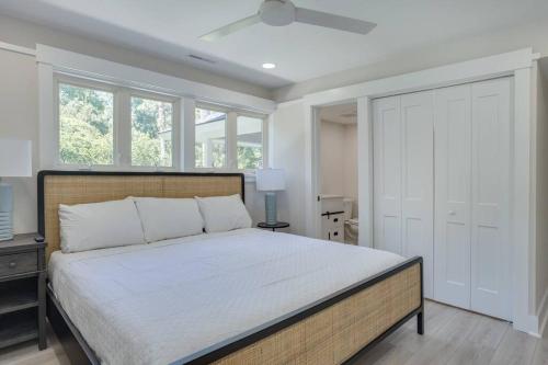 a bedroom with a large bed and windows at Luxury Beach House - 2min Walk to Beach - Private Pool - Group & Dog Friendly in Hilton Head Island