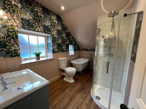 a bathroom with a shower and a toilet and a sink at Quaint self contained cottage near Edinburgh. in Loanhead