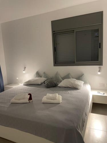 a large white bed with two towels on it at SEA & FUN in H̱adera