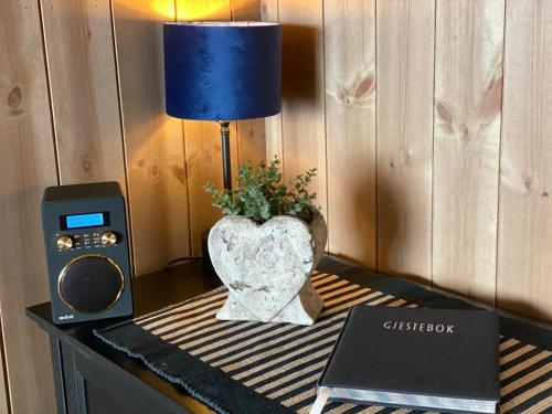 a room with a table with a lamp and a heart vase at New apartment, Gausta in Rjukan. Ski in/ ski out in Rjukan