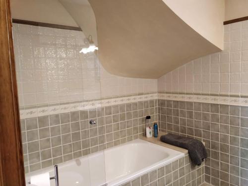 a bathroom with a bath tub in a tiled room at Relax y naturaleza en Bourg-Madame/Puigcerdà. in Bourg-Madame
