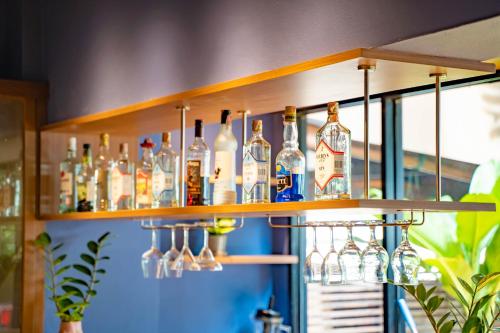 a shelf filled with bottles and glasses on a wall at The Cottage Suvarnabhumi in Lat Krabang