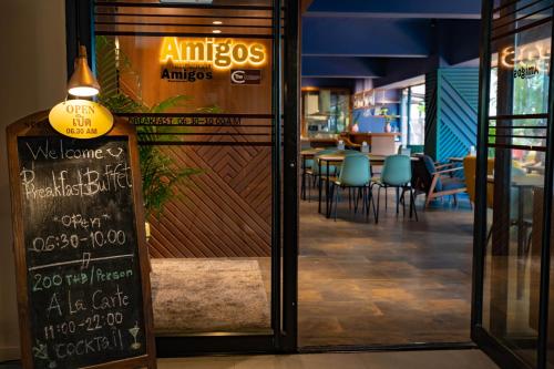 a restaurant with a chalkboard sign next to a table at The Cottage Suvarnabhumi in Lat Krabang