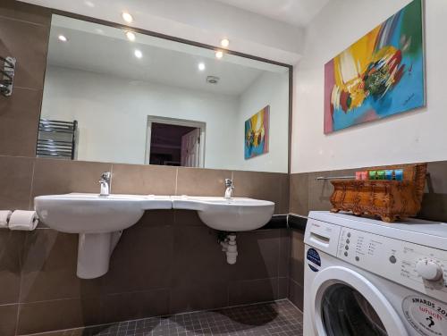 a bathroom with two sinks and a washing machine at Twenty Nevern Square Hotel in London