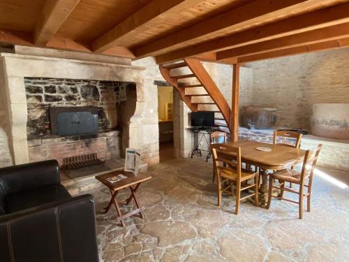 - un salon avec une table et une cheminée dans l'établissement Domaine de la Laigne - Spa, à Asnières-la-Giraud