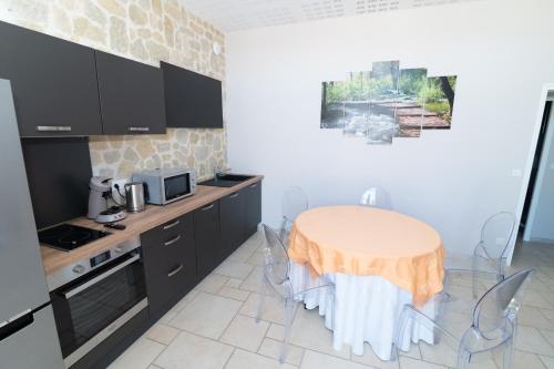eine Küche mit einem Tisch und Stühlen im Zimmer in der Unterkunft Ferme d'Auxonnettes in Saint-Fargeau-Ponthierry