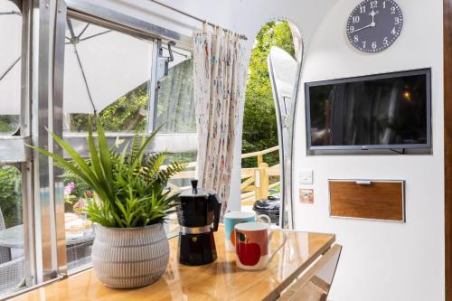 a room with a table and a clock and a window at The 1956 Vintage American Airstream in Dittisham