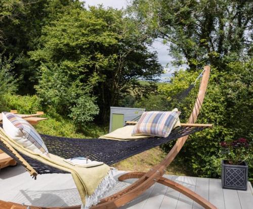 a hammock sitting on top of a patio at The 1956 Vintage American Airstream in Dittisham