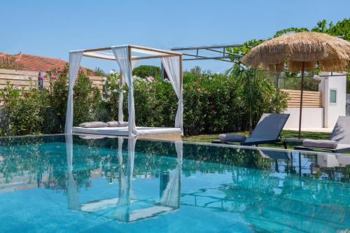 a swimming pool with two lounge chairs and a laptop on it at Sonel Luxury Villa, a Family Retreat, By ThinkVilla in Mouzákion