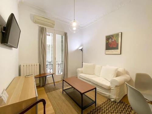 een woonkamer met een witte bank en een tafel bij Montaber Apartments - La Paz Market in Madrid