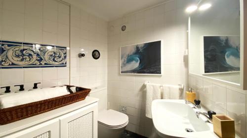 bagno bianco con lavandino e servizi igienici di Estoril Sunny Apartment a Estoril