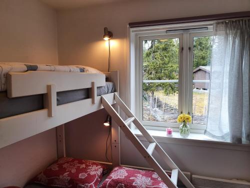 a bedroom with two bunk beds and a window at Fantastic and high standard apartment in Nordseter in Lillehammer