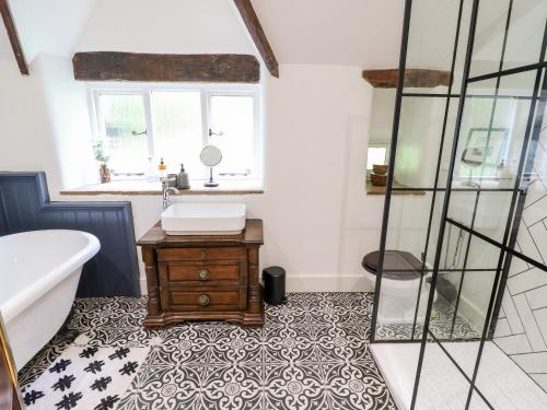 a bathroom with a tub and a sink and a table at Warley Lodge in Halifax