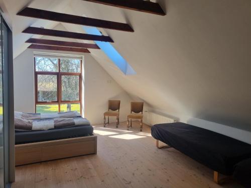 a attic bedroom with two beds and a window at Elling Bed & Breakfast in Frederikshavn