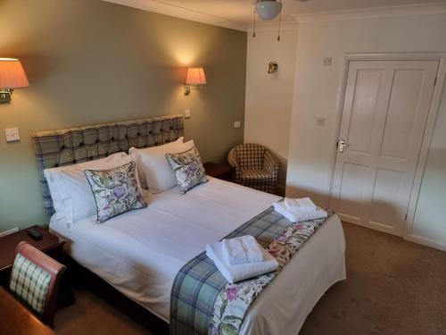 een slaapkamer met een groot wit bed met kussens bij The Courthouse Inn in Colchester