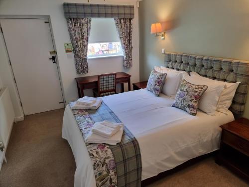 a bedroom with a large bed and a window at The Courthouse Inn in Colchester