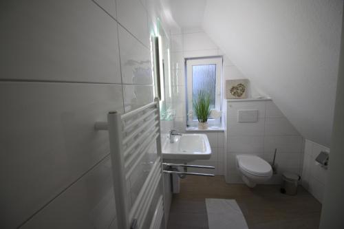 クックスハーフェンにあるHeidhöhn 8の白いバスルーム(洗面台、トイレ付)