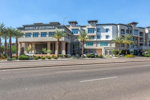 una calle vacía frente a un edificio con palmeras en Kasa Scottsdale North Phoenix en Scottsdale