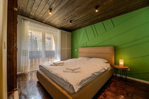 a green bedroom with a bed with a green wall at Blend Mountain Villa in Buşteni
