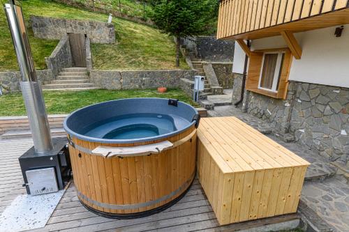 a large tub sitting on a deck with a bench at Blend Mountain Villa in Buşteni